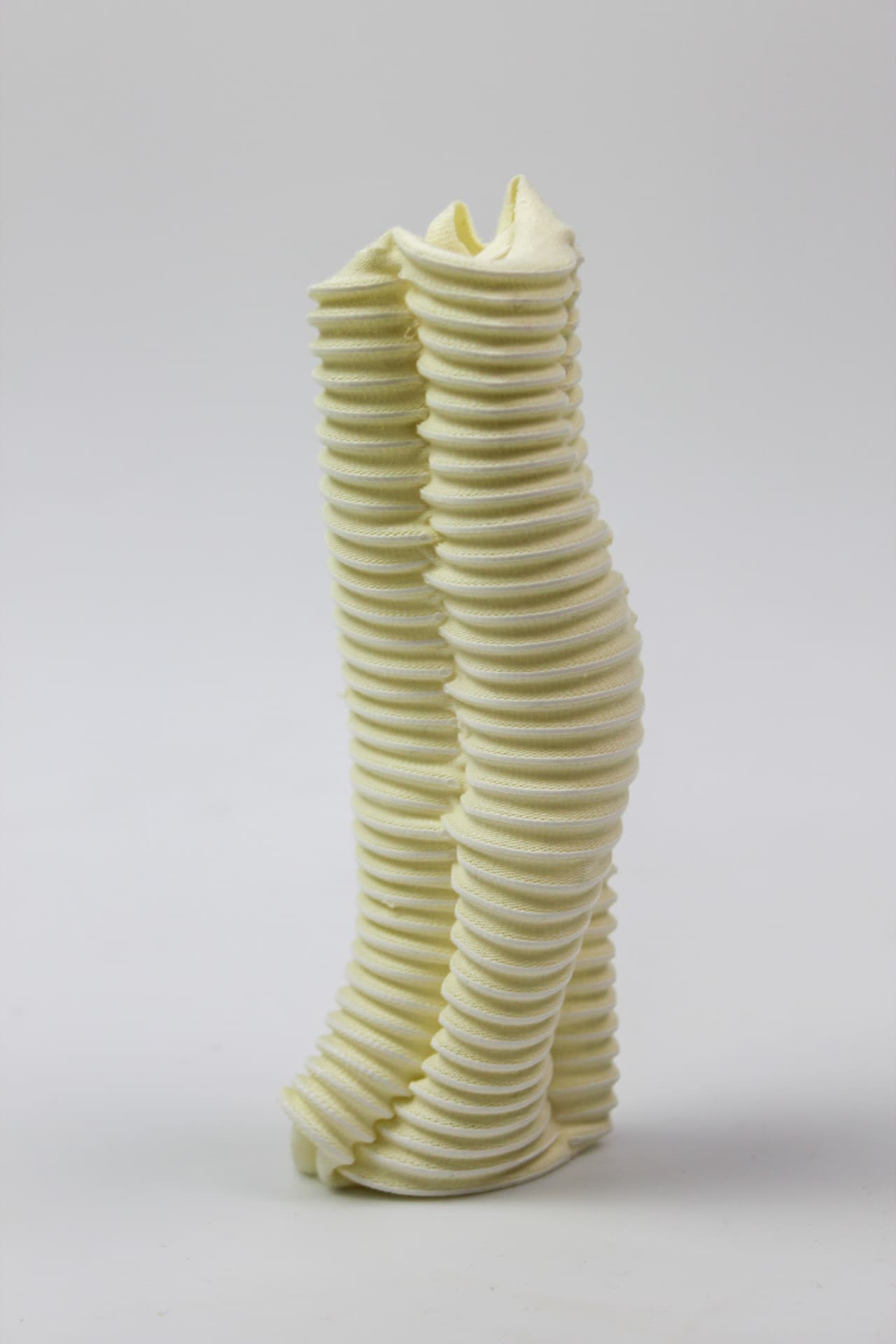 Pale yellow textile column with tightly stacked horizontal ribs.