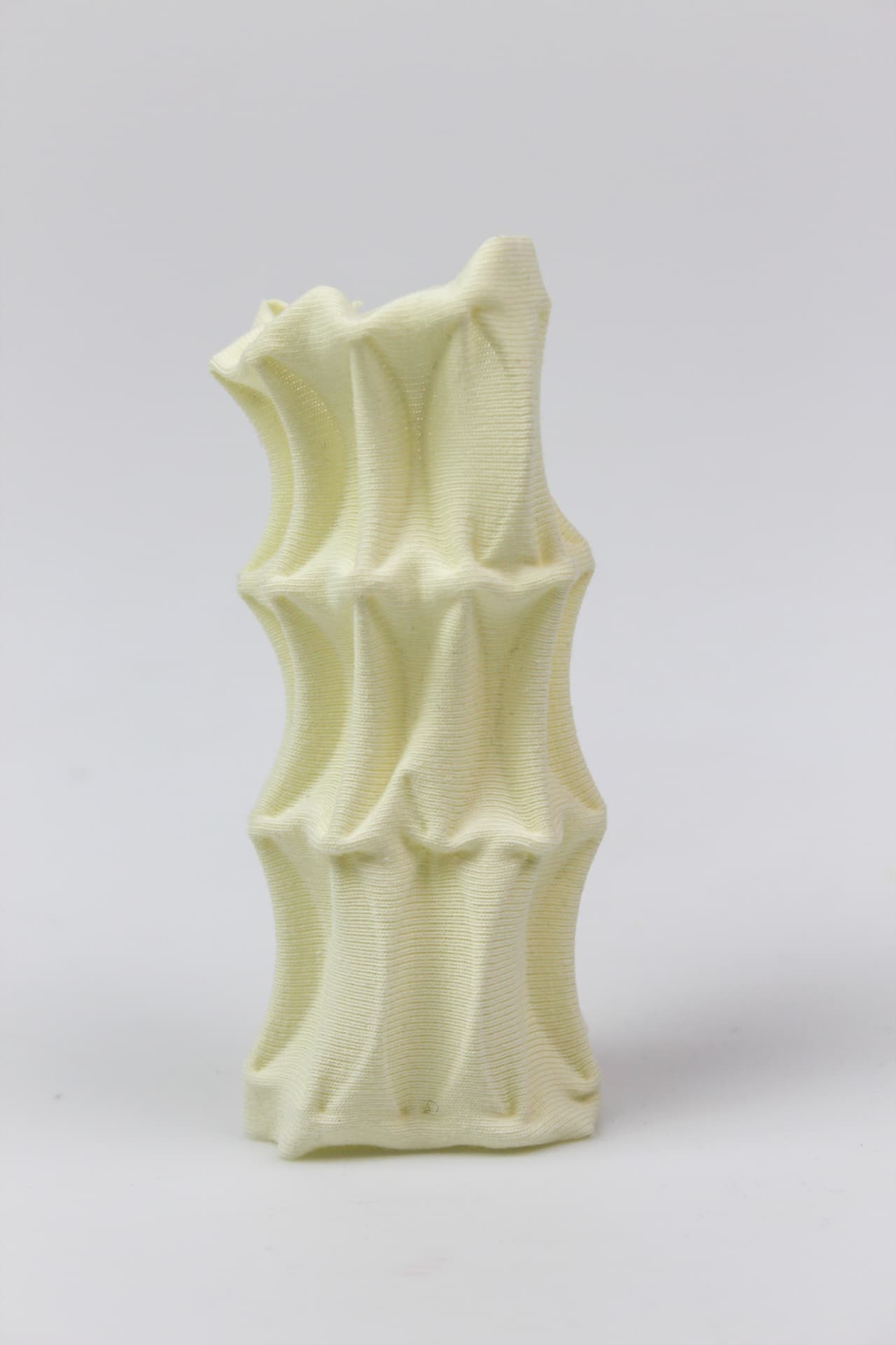 Cream textile column with deep scalloped horizontal folds.