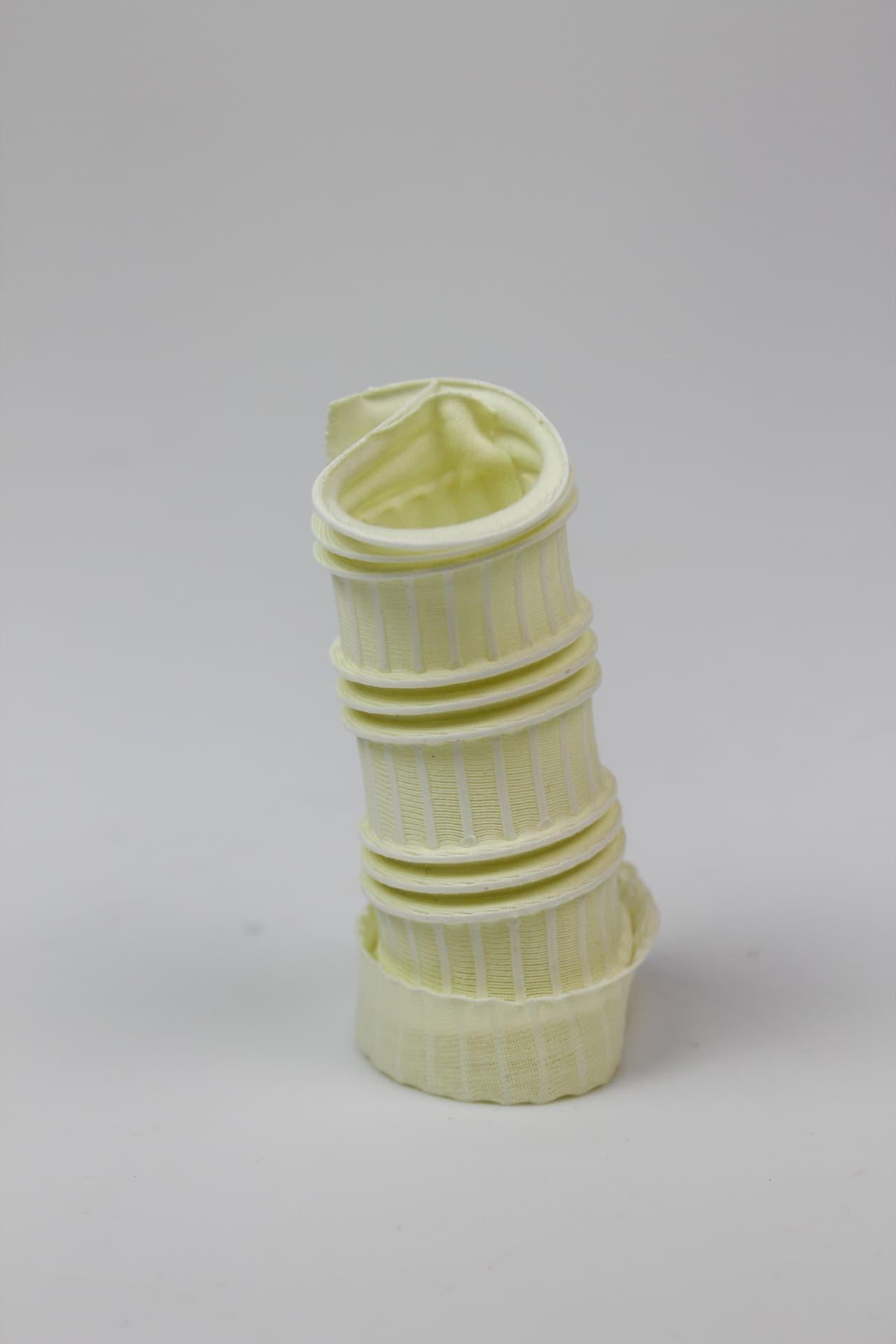 Tapered cream textile column with stacked ribbed segments.